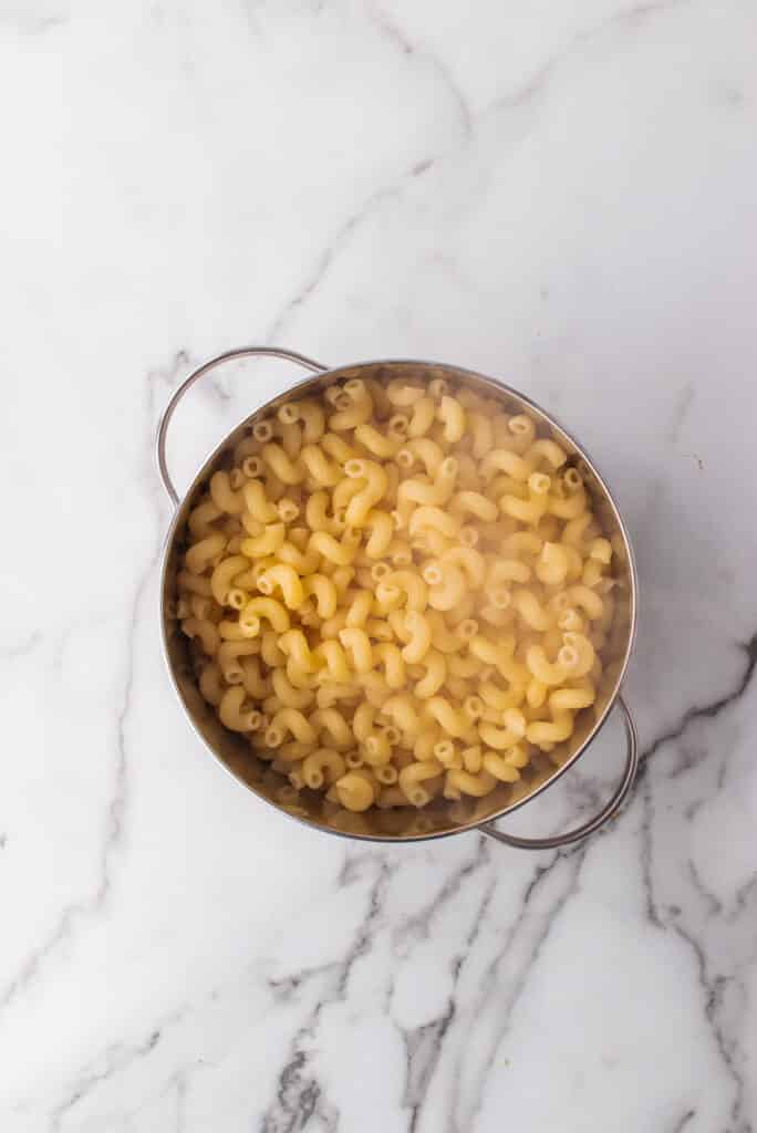 Macarrão com queijo com costelinha refogada em uma mesa de mármore.