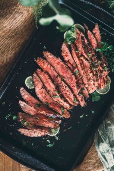 Bife de flanco grelhado em uma assadeira preta.