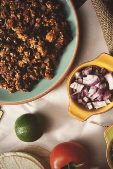 Um prato de tacos de peru em panela elétrica sobre uma mesa.