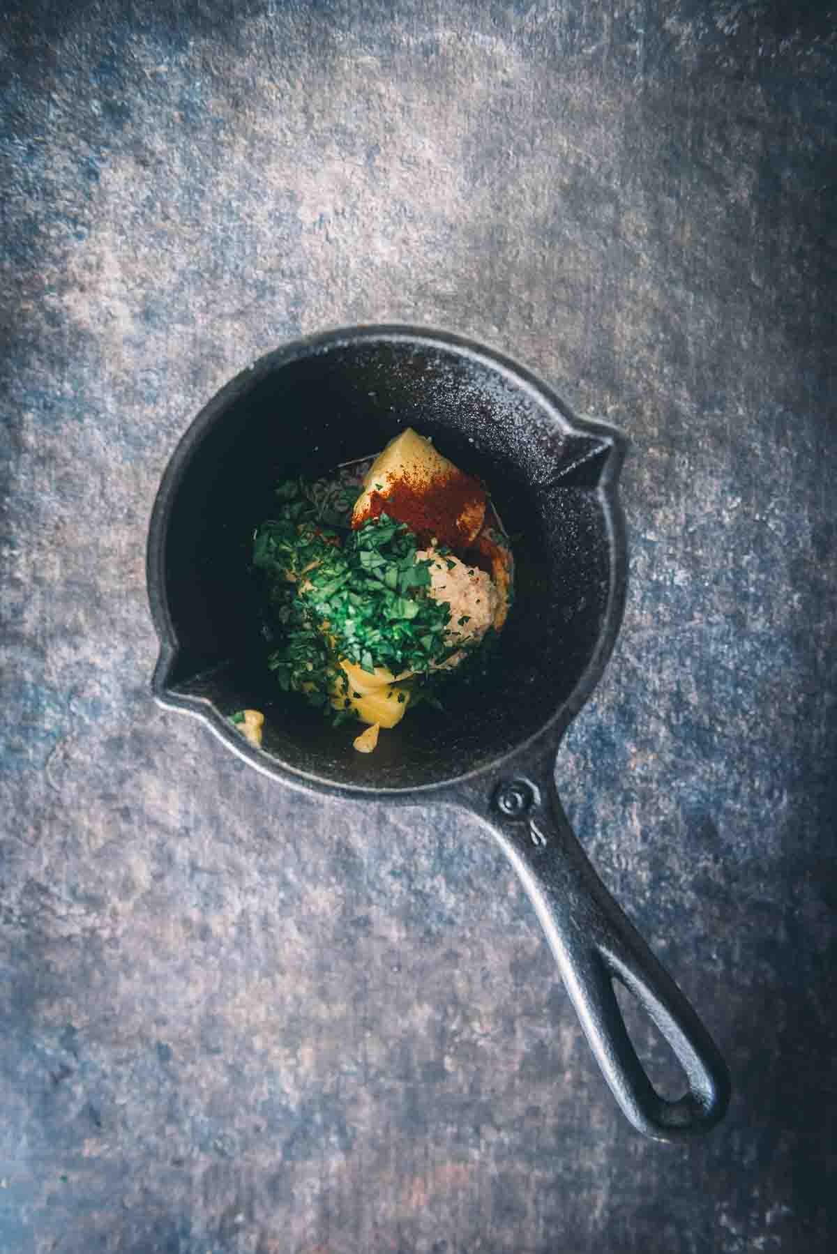 Toda a manteiga e ingredientes em uma pequena panela de ferro fundido.