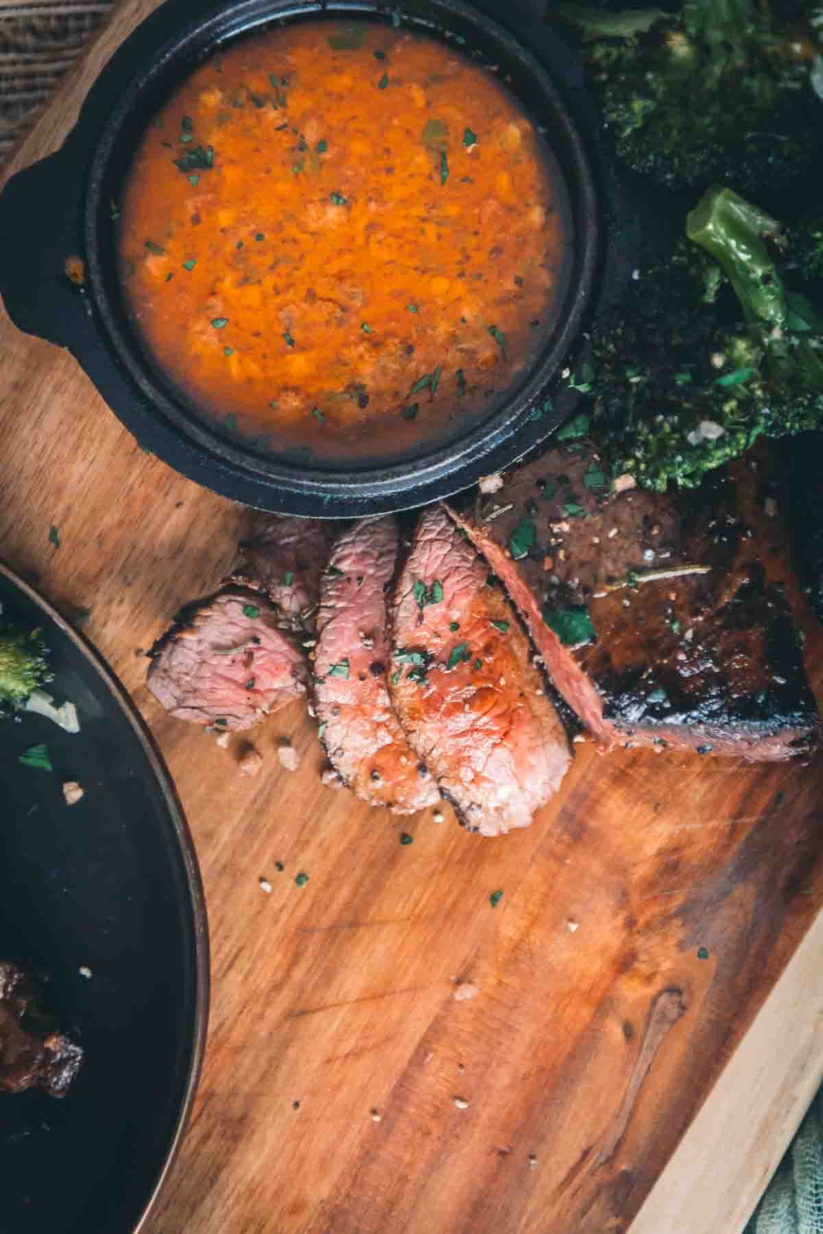 Sobrecarga de bife fatiado ao lado de um pires de manteiga de cowboy.