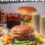 Prato com hambúrguer amassado coberto com alface e cebola, servido com batata frita e bebida; o texto acima diz "Como fazer hambúrgueres de crack quebrados.