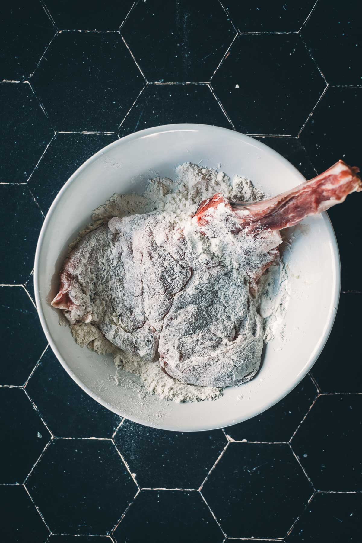 Vitela dragada em uma tigela de farinha.