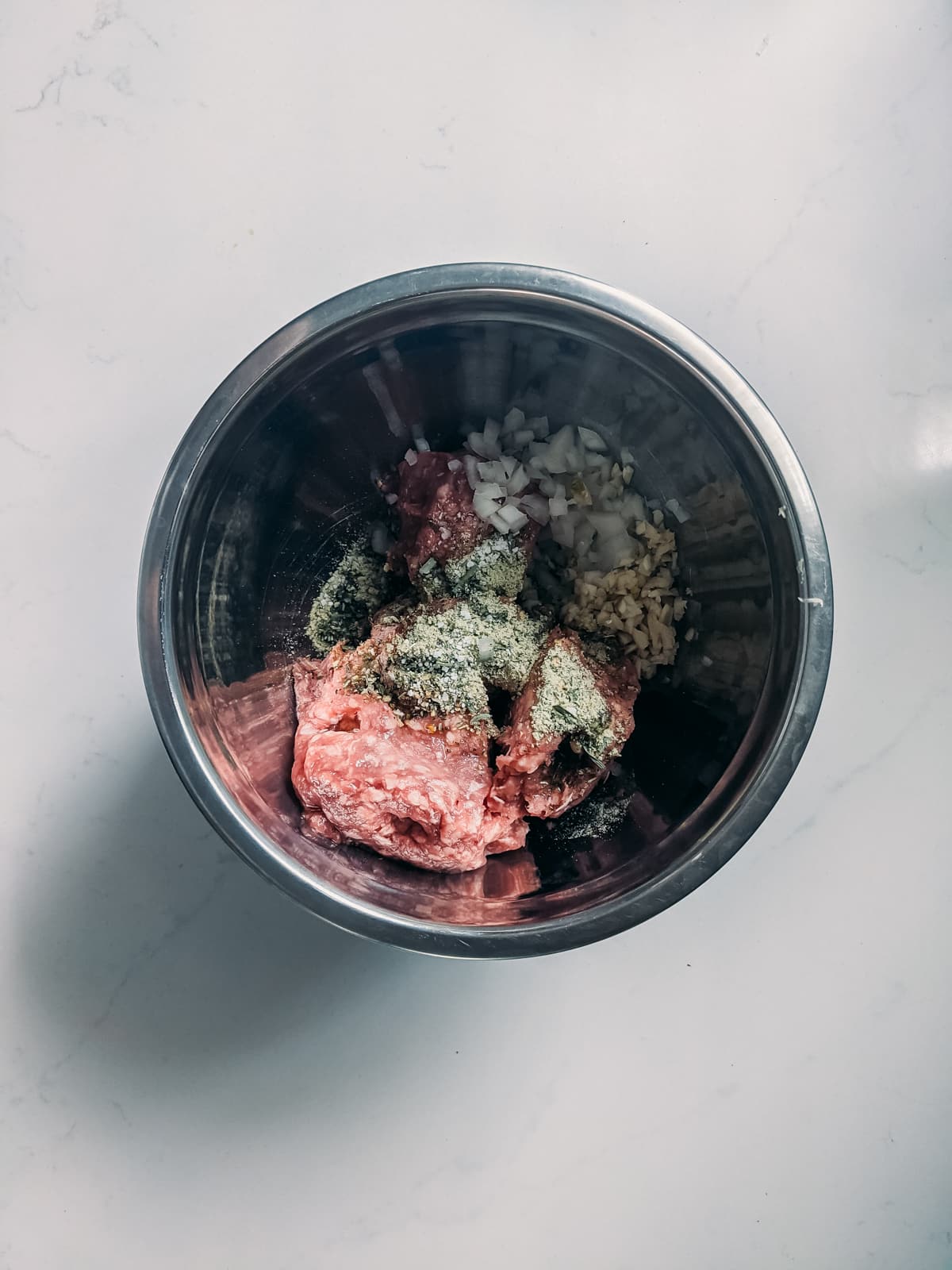 dose de ingredientes de almôndega de cordeiro em uma tigela pronta para ser misturada, cordeiro cru, especiarias, cebola picada, alho