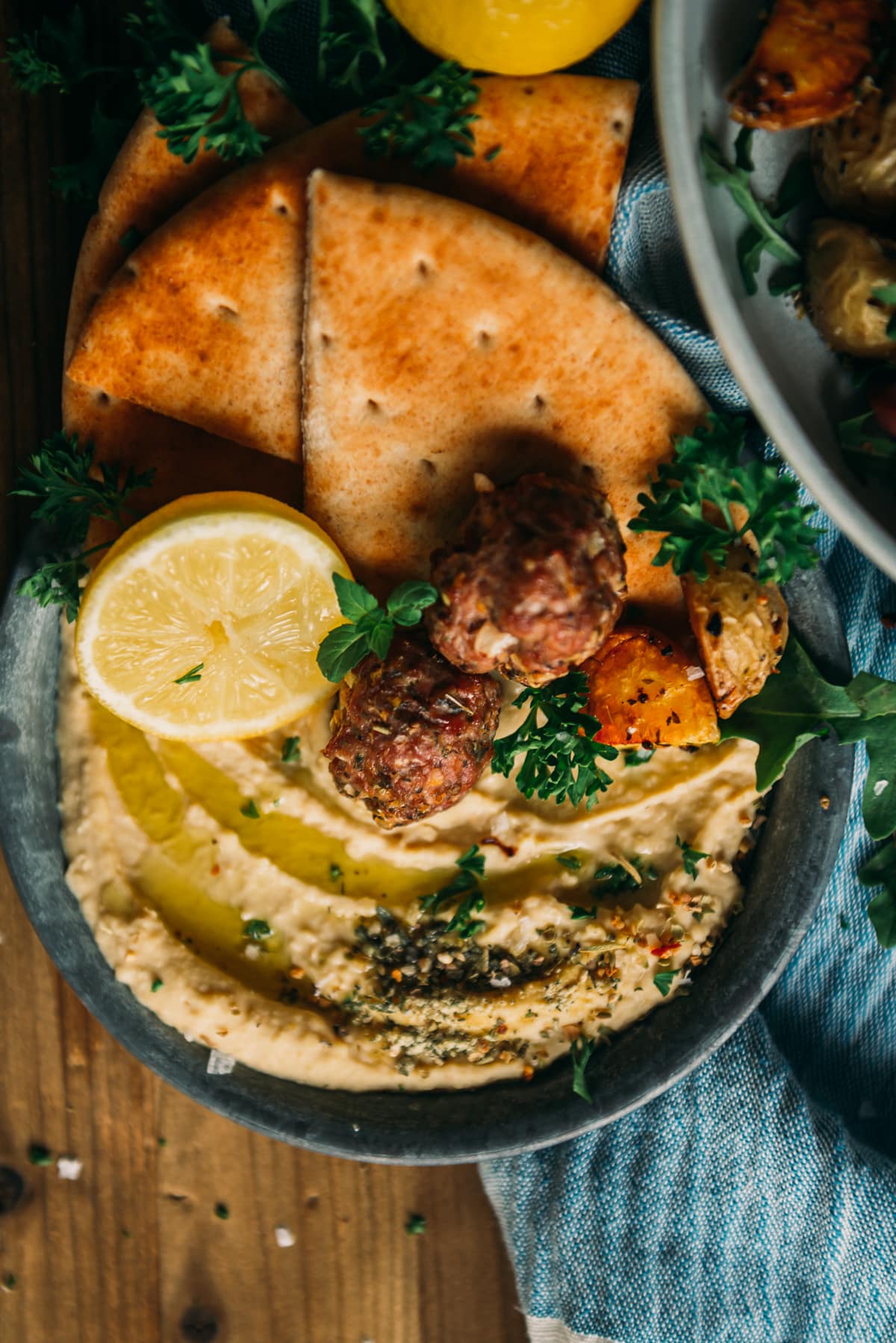 almôndegas de cordeiro no prato sobre hummus de limão com ervas e pão árabe